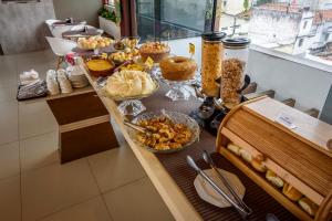 a table with many different types of food on it at Hotel Mais1 in Campina Grande