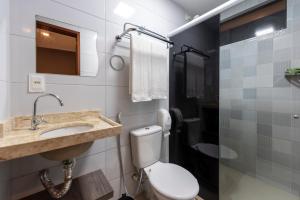a bathroom with a toilet and a sink and a mirror at Hotel Mais1 in Campina Grande +37 photos