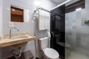 a bathroom with a toilet and a sink and a mirror at Hotel Mais1 in Campina Grande