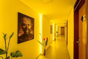 a hallway with a painting of a man on the wall at Hotel Mais1 in Campina Grande