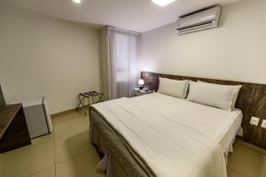 a bedroom with a large white bed in a room at Hotel Mais1 in Campina Grande