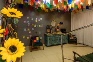 a room with a wall with cards and sunflowers at Hotel Mais1 in Campina Grande