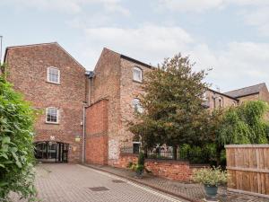an old brick building with a tree in front of it at 6 Granary Court in York