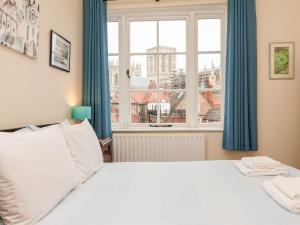 a bedroom with a bed and a large window at 6 Granary Court in York