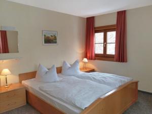 een slaapkamer met een bed met witte lakens en kussens bij Ferienhaus Haus Tanneck in Kurort Altenberg