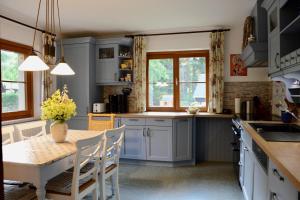a kitchen with blue cabinets and a table with chairs at Ferienhaus Haus Tanneck in Kurort Altenberg