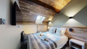 a bedroom with a bed with two towels on it at Nouveau ! Chalet pied des pistes in Champagny-en-Vanoise