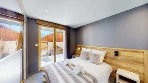 a bedroom with a bed and a large window at Nouveau ! Chalet pied des pistes in Champagny-en-Vanoise