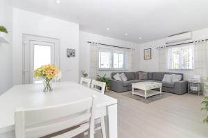 a living room with a white table and a couch at Casa Pachorrenta in Carvoeiro