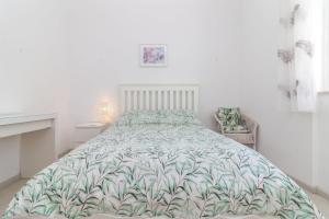 a bedroom with a bed with a green and white blanket at Casa Pachorrenta in Carvoeiro +14 photos