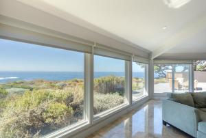 un soggiorno con ampie finestre e un divano di 3906 Ocean's One Eleven home a Carmel