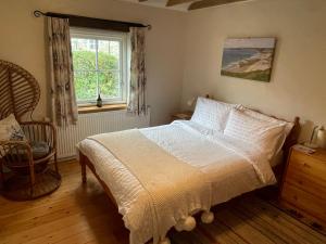 a bedroom with a bed and a window at The Dairy @ Trefechan Wen in Goodwick