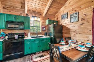 a kitchen with green cabinets and a wooden wall at A Top Notch Lodge~Gatlinburg in Gatlinburg