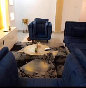 a living room with a blue couch and a table at appartement cosy free bonapriso in Douala
