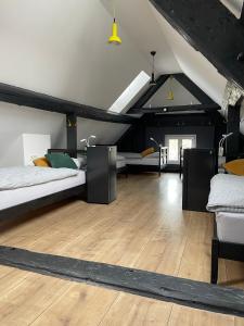 1 dormitorio en el ático con 2 camas y suelo de madera en Sax Pub Hostel Ljubljana, en Liubliana