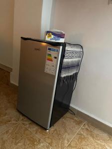 a small refrigerator with a blanket on top of it at Simple home in Madaba