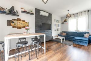 uma sala de estar com um bar e um sofá azul em La casa di Vittoria em Arona