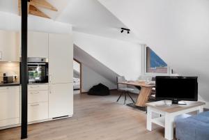 Apartement Bens Auszeit Top 5 في امهاوسن: مطبخ وغرفة معيشة مع مكتب وتلفزيون