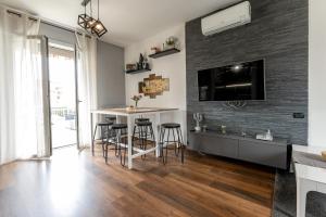 a kitchen with a bar with stools and a tv at La casa di Vittoria in Arona