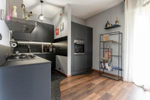 a kitchen with black cabinets and wooden floors at La casa di Vittoria in Arona