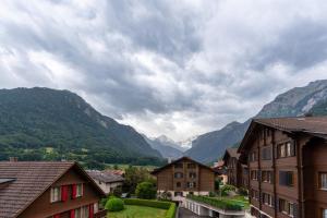 a view of a town with mountains in the background at Alpenblick mit Balkon nahe Interlaken in Wilderswil