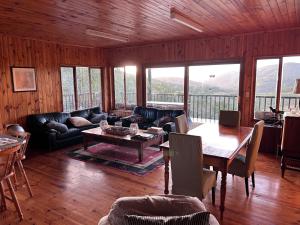 een woonkamer met een bank en een tafel bij Keurbooms River Game Trails in Plettenbergbaai