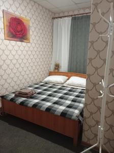 ein Schlafzimmer mit einem Bett mit einer schwarz-weiß karierten Decke in der Unterkunft DESYATINNAYA Hostel in Kiew