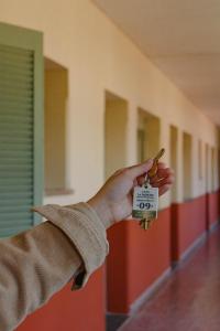 a persons hand holding a door key in a hallway at Alojamiento en pleno centro de Corrientes in Corrientes