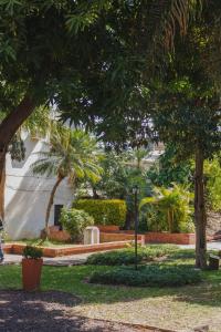 un parque con árboles y un edificio blanco en Alojamiento en pleno centro de Corrientes en Corrientes