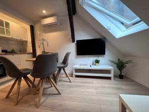 a living room with a tv and a table and chairs at Studio apartman Mia in Zagreb