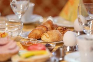 a table topped with plates of pastries and eggs at Appartementhaus Dachsteinblick in Bad Goisern