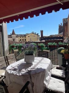 a table with a vase of flowers on a patio at La Suite di Giulia in Ferrara