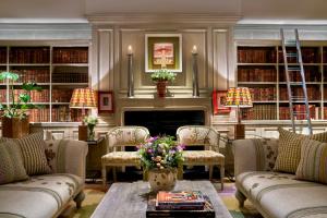 a living room with couches and a fireplace in a library at The Soho Hotel, Firmdale Hotels in London