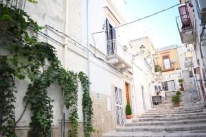Une allée dans une vieille ville avec des escaliers dans l'établissement Faliero Room, à Canosa di Puglia
