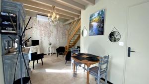 a living room with a dining room table and chairs at La petite charmille in Châteauponsac