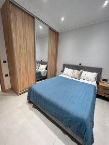 a bedroom with a large bed with a blue blanket at KONTIS' Furnished apartment in Loutraki