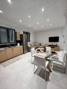 a kitchen and living room with a table and chairs at KONTIS' Furnished apartment in Loutraki