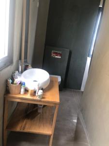 a bathroom with a white sink on a wooden table at NDARI in Siendou