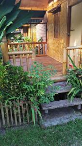 een houten veranda met een bank en een aantal planten bij Farmer homestay in Tetebatu