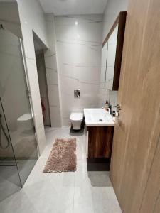 a bathroom with a sink and a toilet and a mirror at KONTIS' Furnished apartment in Loutraki
