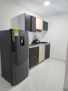 a kitchen with a stainless steel refrigerator and cabinets at Hermoso apartamento in Pitalito