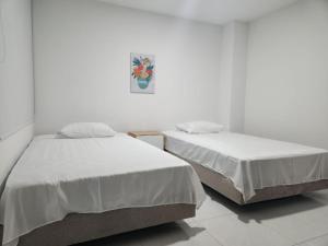 two beds sitting next to each other in a room at Hermoso apartamento in Pitalito