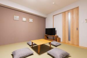 京都市にあるHOTEL ECCLESIAのテーブルとテレビのあるリビングルーム
