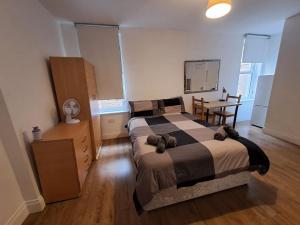 a bedroom with a bed and a table and a desk at Private self-contained studio close to Hampstead, Golders Green & Camden Town in London