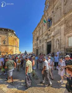 un gran grupo de personas de pie frente a un edificio en Acasadifelice, en Matera