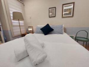 Cama blanca con sábanas blancas y almohadas azules en Starman's Gem by Inspired Homes, 4Pax en Puchong