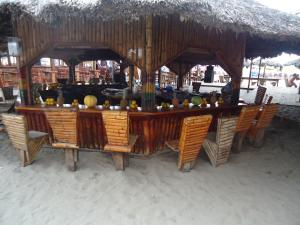 un restaurant avec une table, des chaises et un toit de chaume dans l'établissement Departamento 4 habitaciones 12 personas vista al mar 8vo piso Playa Almendro, à Tonsupa