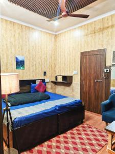 a bedroom with a bed and a ceiling fan at Metroview rooms & hotel in Bahādurgarh
