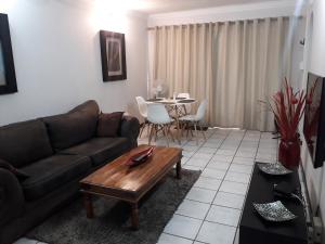 a living room with a couch and a table at Protea Park Self Catering Guesthouse in Rustenburg
