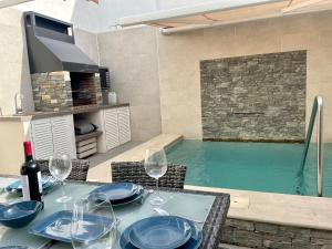 una mesa de comedor con copas de vino y una piscina en Casa El Patio, en Chiclana de la Frontera